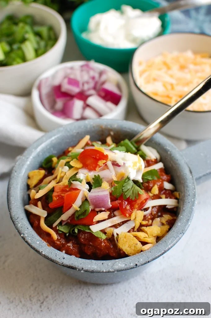 Hearty Classic Beef Chili served in a rustic blue bowl, garnished with fresh cilantro and a dollop of sour cream.