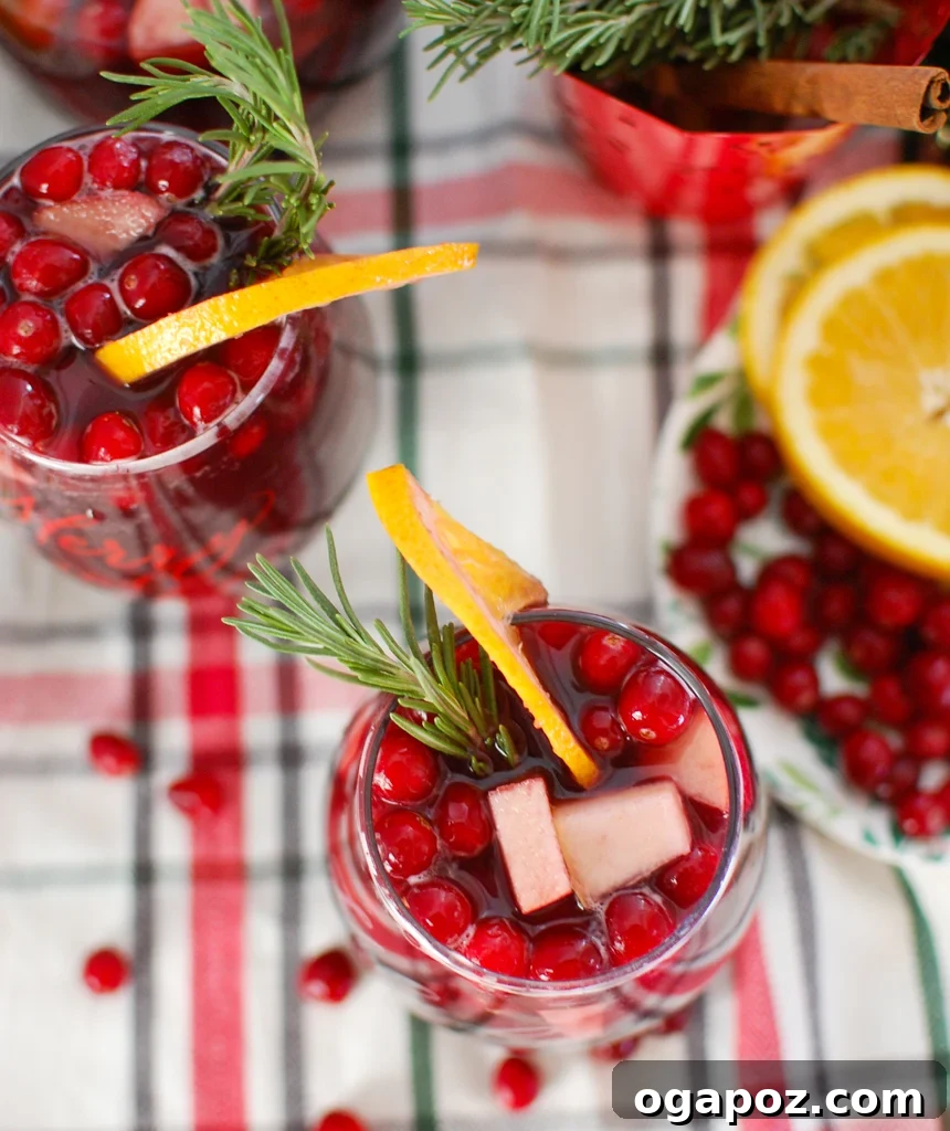 Holiday Cheer Sangria 4 Christmas Sangria in a pitcher with fresh cranberries and rosemary