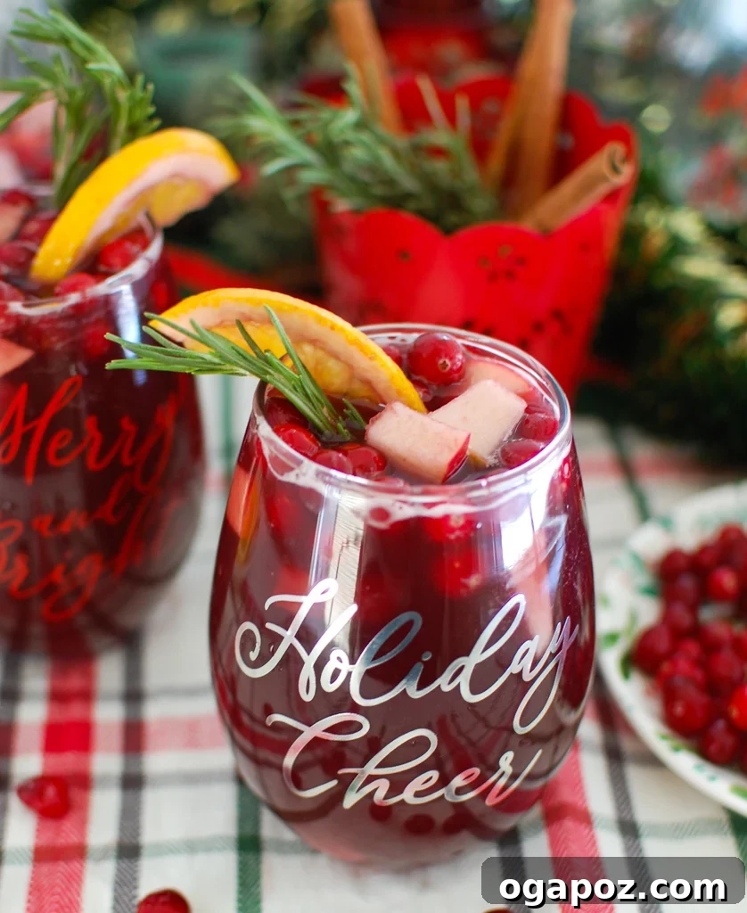 Holiday Cheer Sangria 5 Close-up of Christmas Sangria with fresh rosemary and cinnamon sticks