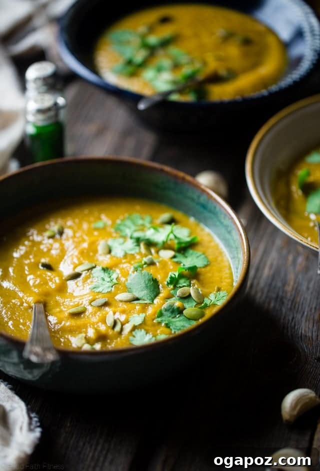 A creamy bowl of Moroccan Roasted Acorn Squash Soup, a spicy, sweet, and healthy vegan and paleo-friendly meal, garnished with herbs.