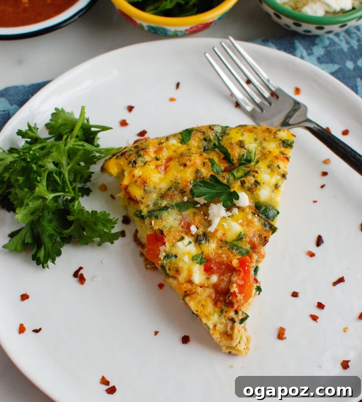 A vibrant Mediterranean Frittata with Moroccan flavors, baked with colorful vegetables, fluffy eggs, and spicy harissa paste, topped with feta and herbs.