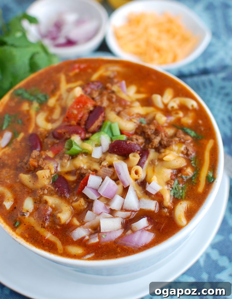 Ultimate Instant Pot Chili Mac 2 Instant Pot Chili Mac in a white bowl, ready to be served with a spoon