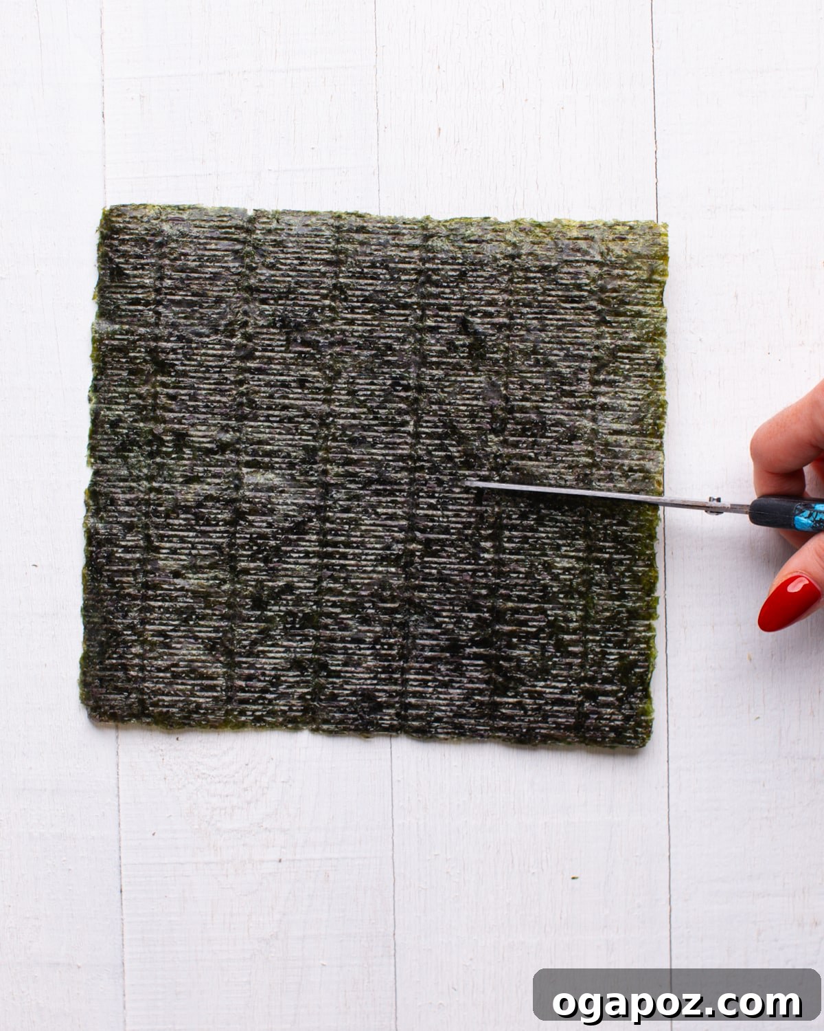 The Ultimate TikTok Sushi Bake 7 Nori seaweed sheets being cut into smaller, perfectly sized squares for serving.