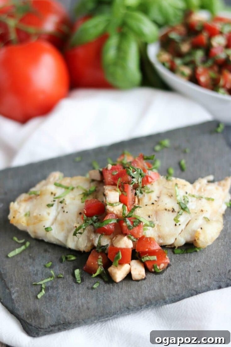 Caprese Grilled Fish, topped with tomatoes, mozzarella, and basil.