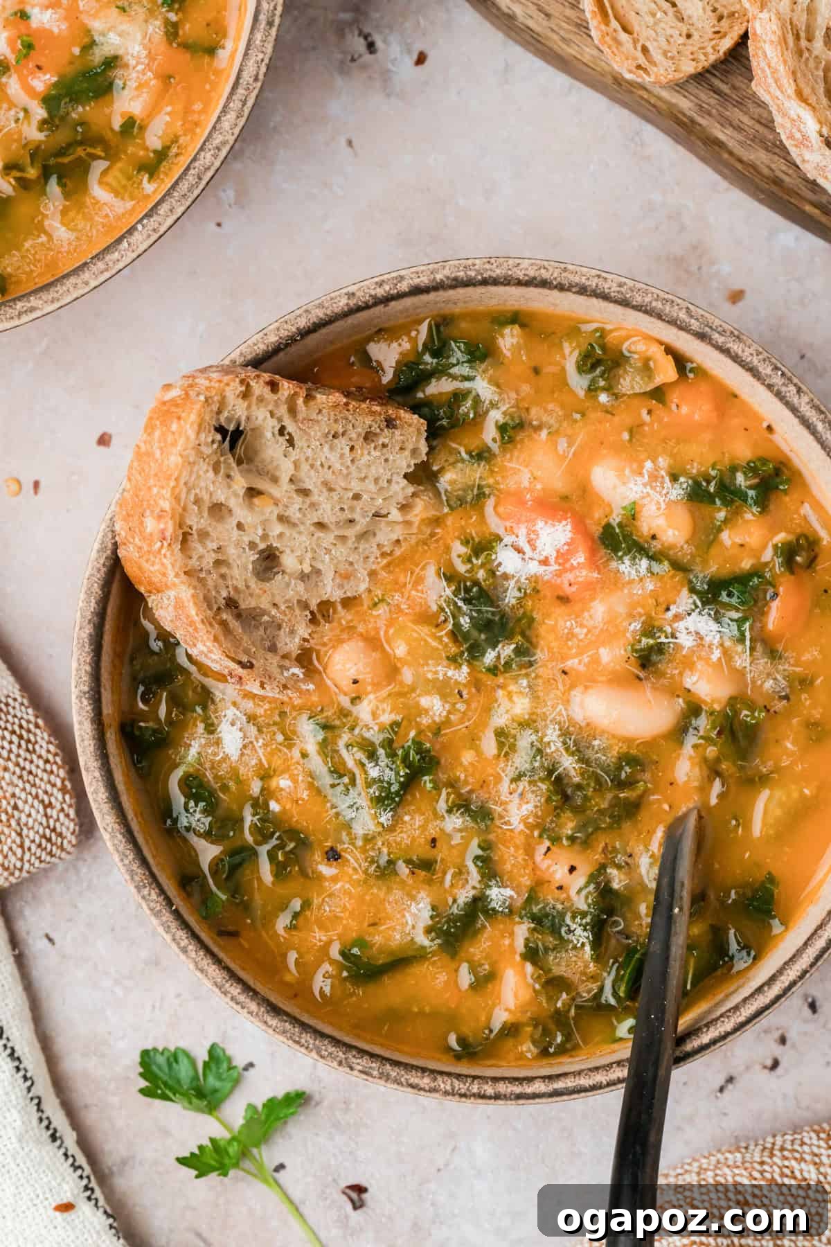 A rustic bowl filled with hearty Tuscan white bean soup, garnished with fresh herbs and a drizzle of olive oil, ready to be enjoyed as a comforting meal.