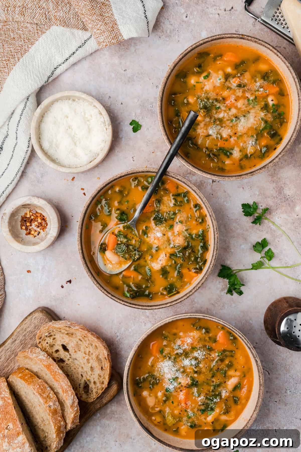 A spoonful of homemade Italian white bean soup featuring vibrant kale, carrots, and celery, showcasing the fresh and wholesome ingredients in a rustic bowl.