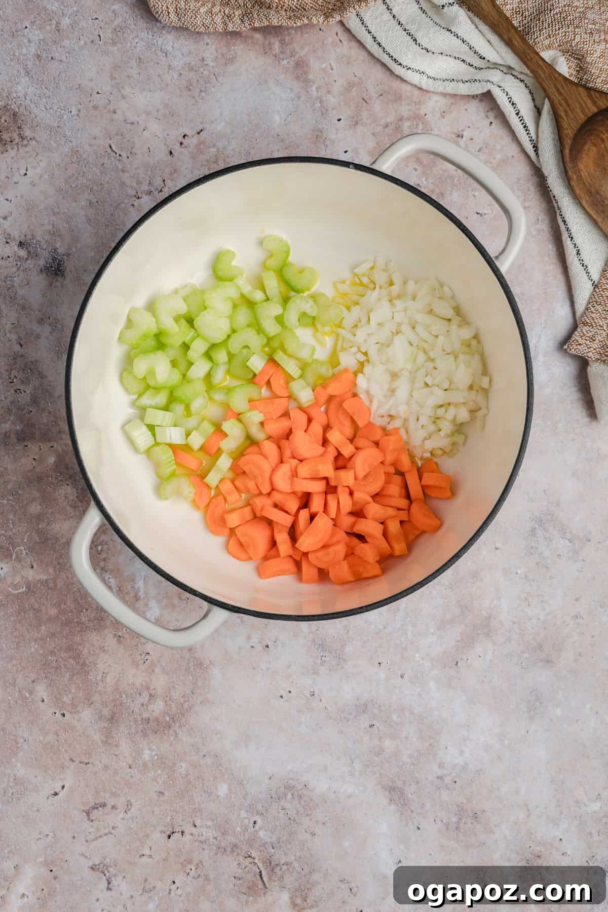Freshly diced onions, carrots, and celery sautéing in olive oil in a large pot or Dutch oven, forming the aromatic base for Tuscan White Bean Soup.