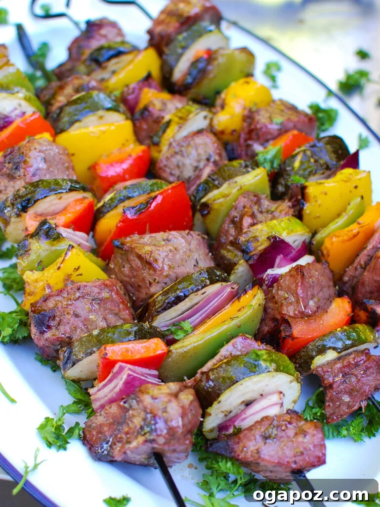 Grilled Mediterranean Beef Skewers 2 Grilled Mediterranean Beef Kabobs on a white platter, showcasing vibrant colors and perfect grill marks
