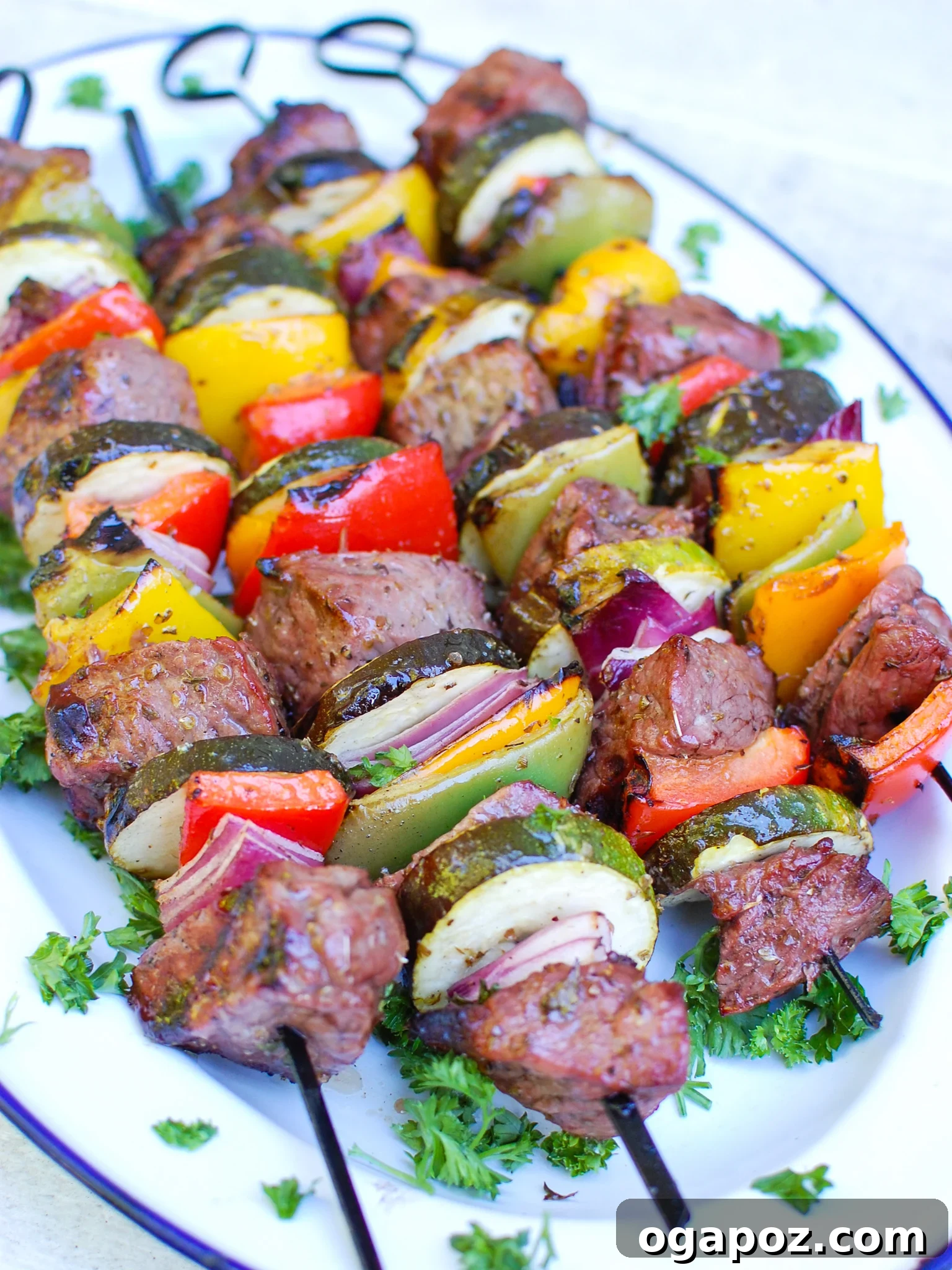 Grilled Mediterranean Beef Skewers 6 Plated Mediterranean Beef Kabobs garnished with fresh parsley on a white plate