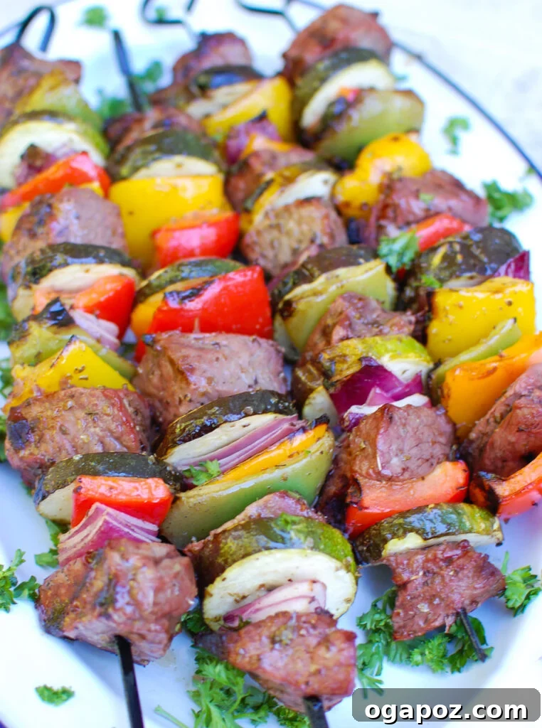 Grilled Mediterranean Beef Skewers 7 Assortment of Mediterranean Beef Kabobs on a large serving platter with fresh herbs