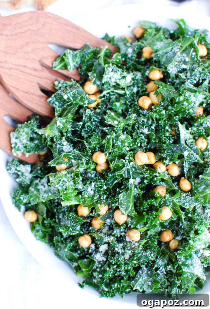 Elevated Kale Caesar 2 Freshly prepared Kale Caesar Salad in a pristine white bowl, garnished with Parmesan and crispy chickpeas.