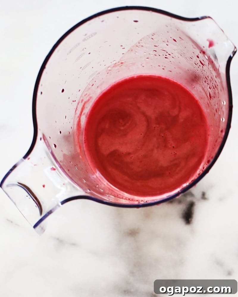 Vibrant ABC Blend 3 A close-up shot of the vibrant red ABC juice in a glass, with small bubbles.