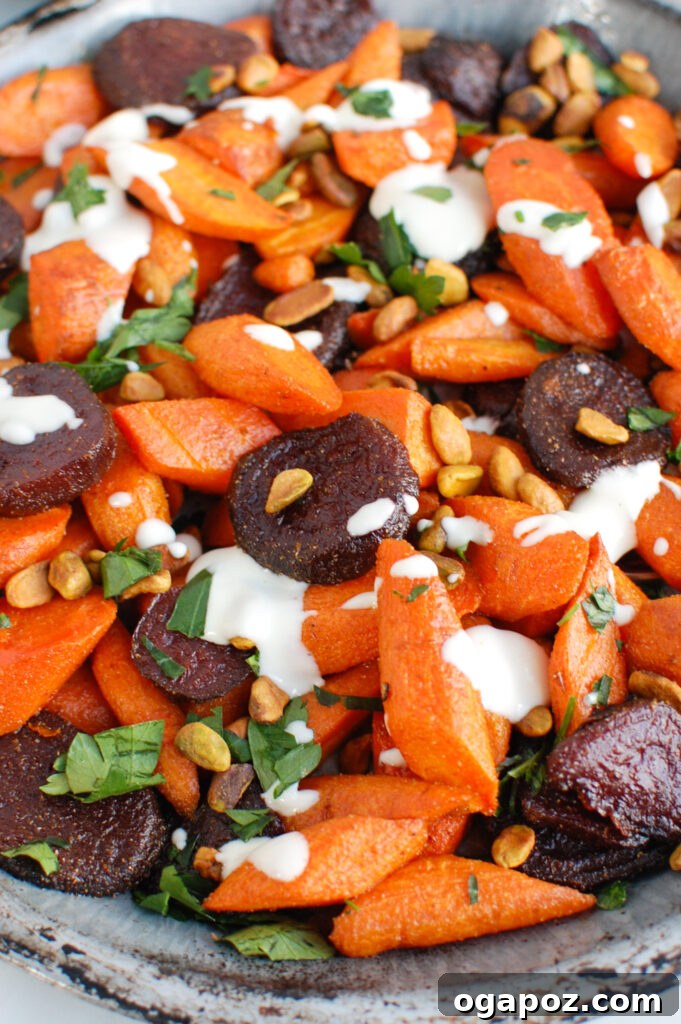 Mediterranean Roasted Roots with Tahini Drizzle 3 Close-up of roasted carrots and beets with a spoon, showing the vibrant colors and tahini drizzle.