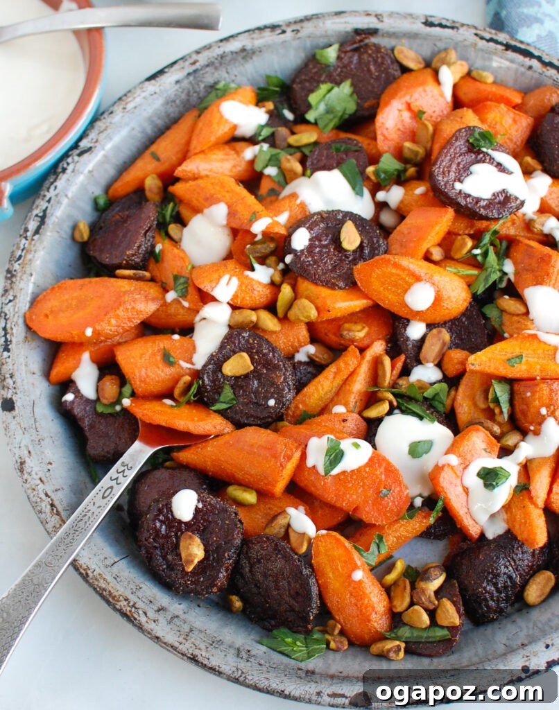 Mediterranean Roasted Roots with Tahini Drizzle 5 Serving roasted carrots and beets with tahini, showing a scoop ready to be plated.