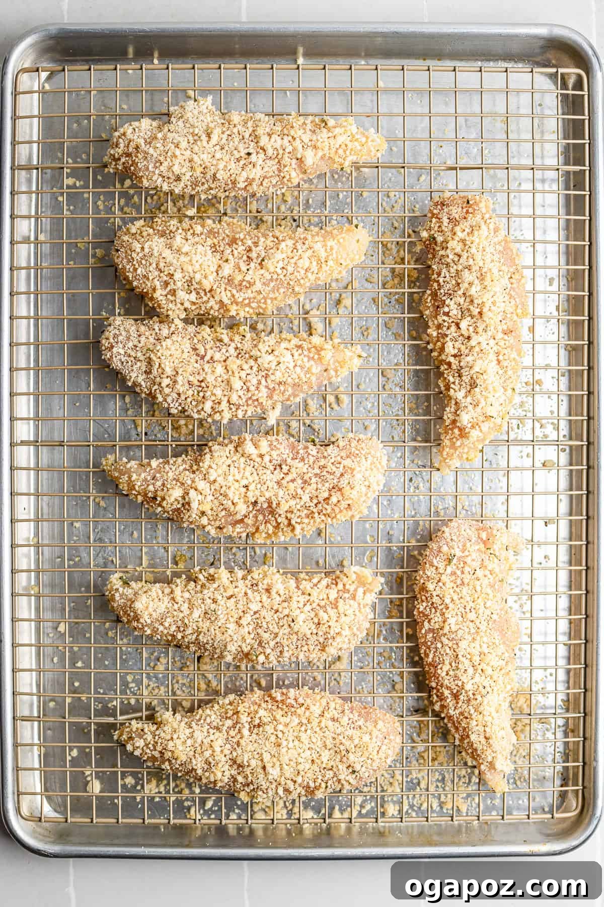 Golden Crispy Oven Baked Chicken Tenders 6 Step 3 – breaded chicken tenders arranged on wire rack ready for oven.