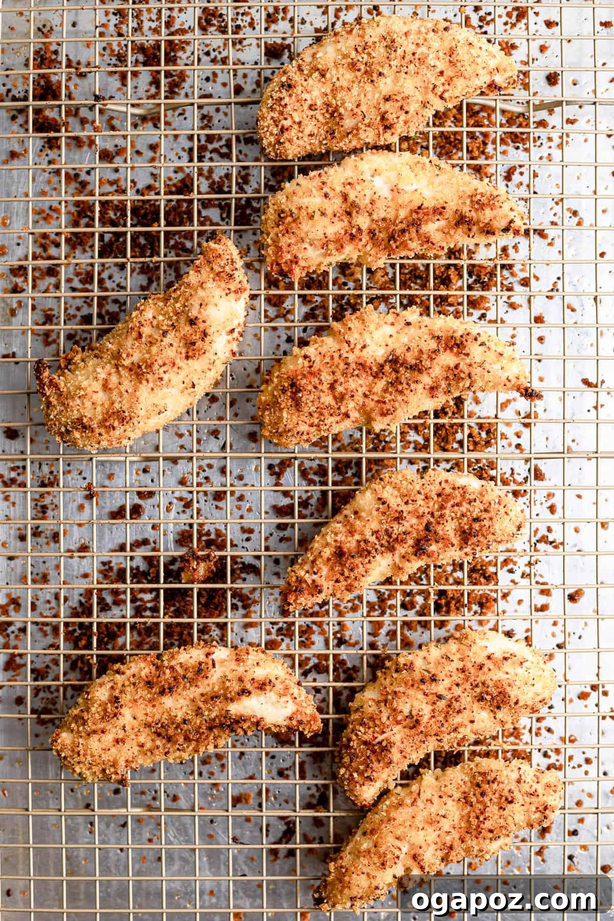Golden Crispy Oven Baked Chicken Tenders 7 Baked chicken tenders cooling on a wire rack, golden and crispy.