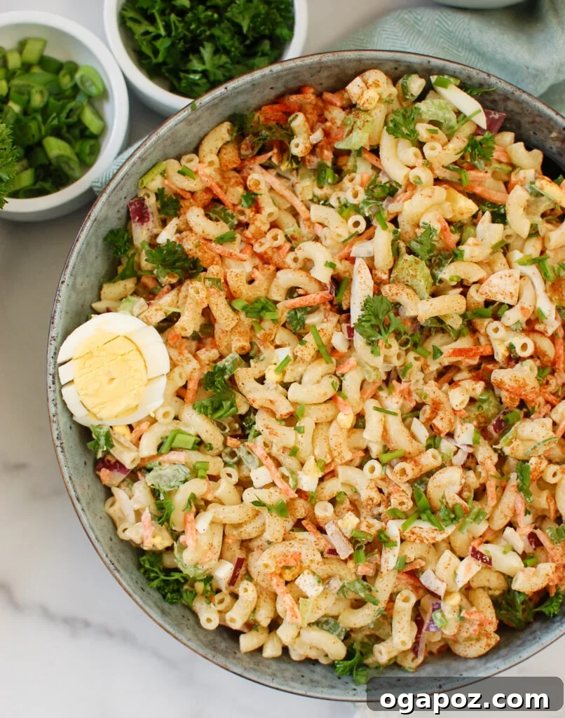 Creamy Macaroni Egg Salad 2 Macaroni Egg Salad in a teal bowl, garnished with fresh herbs