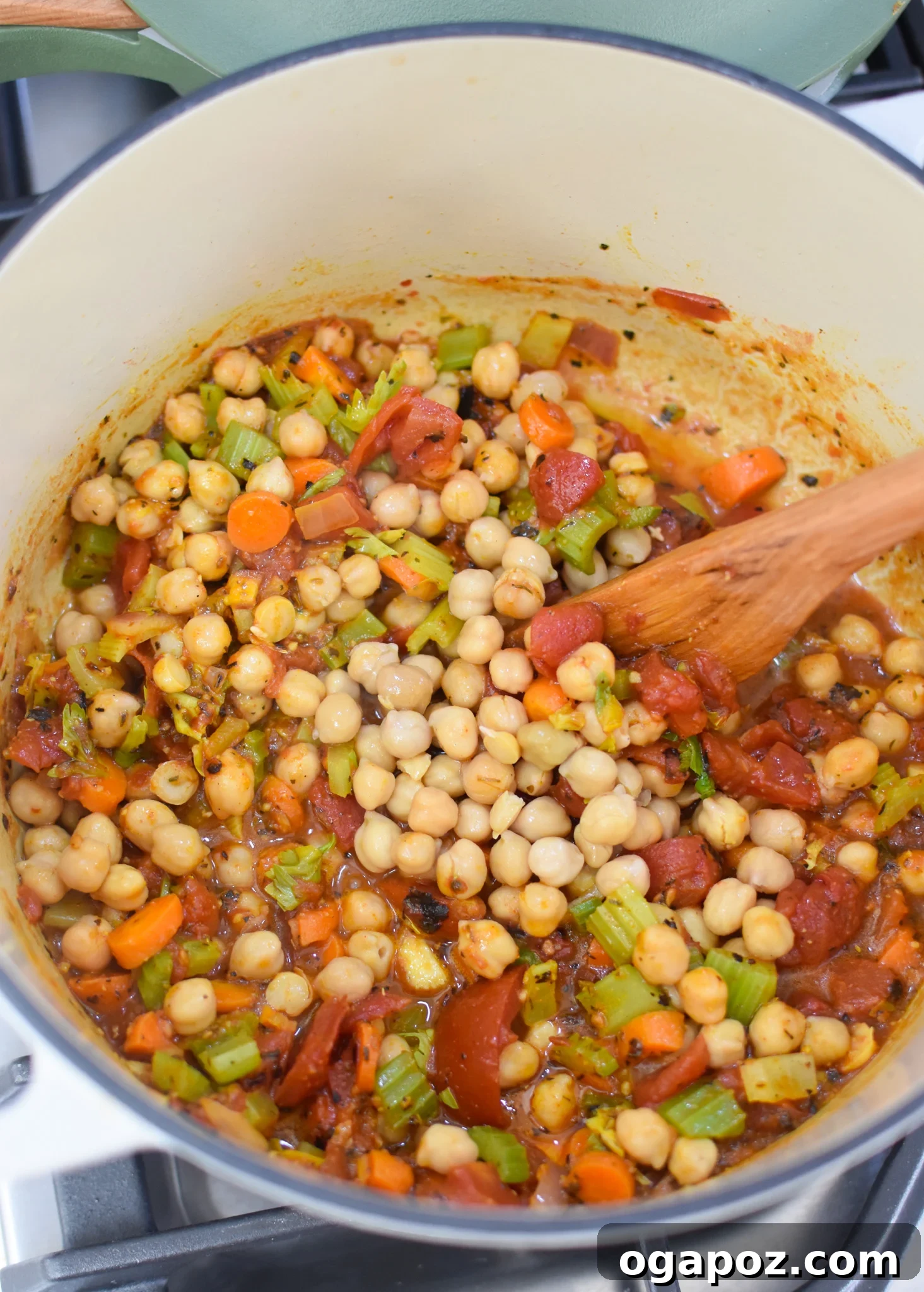 One-Pot Chickpea Comfort 7 Garbanzo Bean Soup ingredients simmering in a Dutch oven on the stove, showing the vibrant colors.