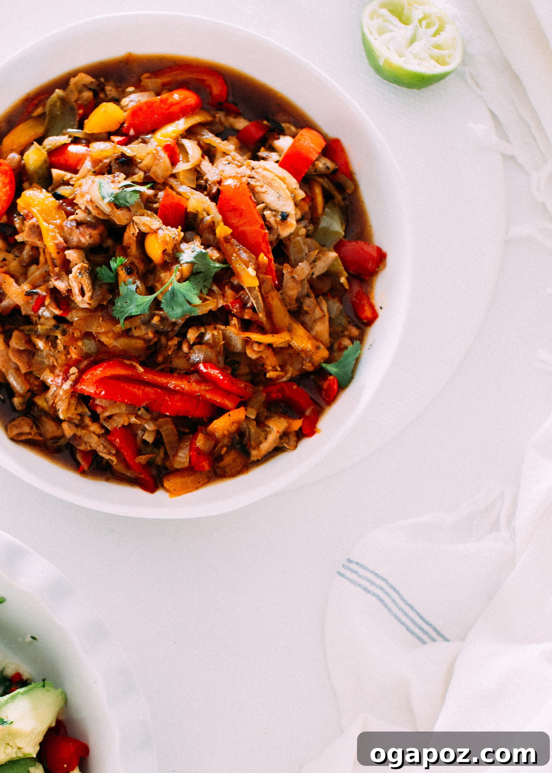 Sizzling Chicken Fajita Skillet 3 Chicken Fajitas served in a White Bowl with Fresh tortillas on a kitchen towel