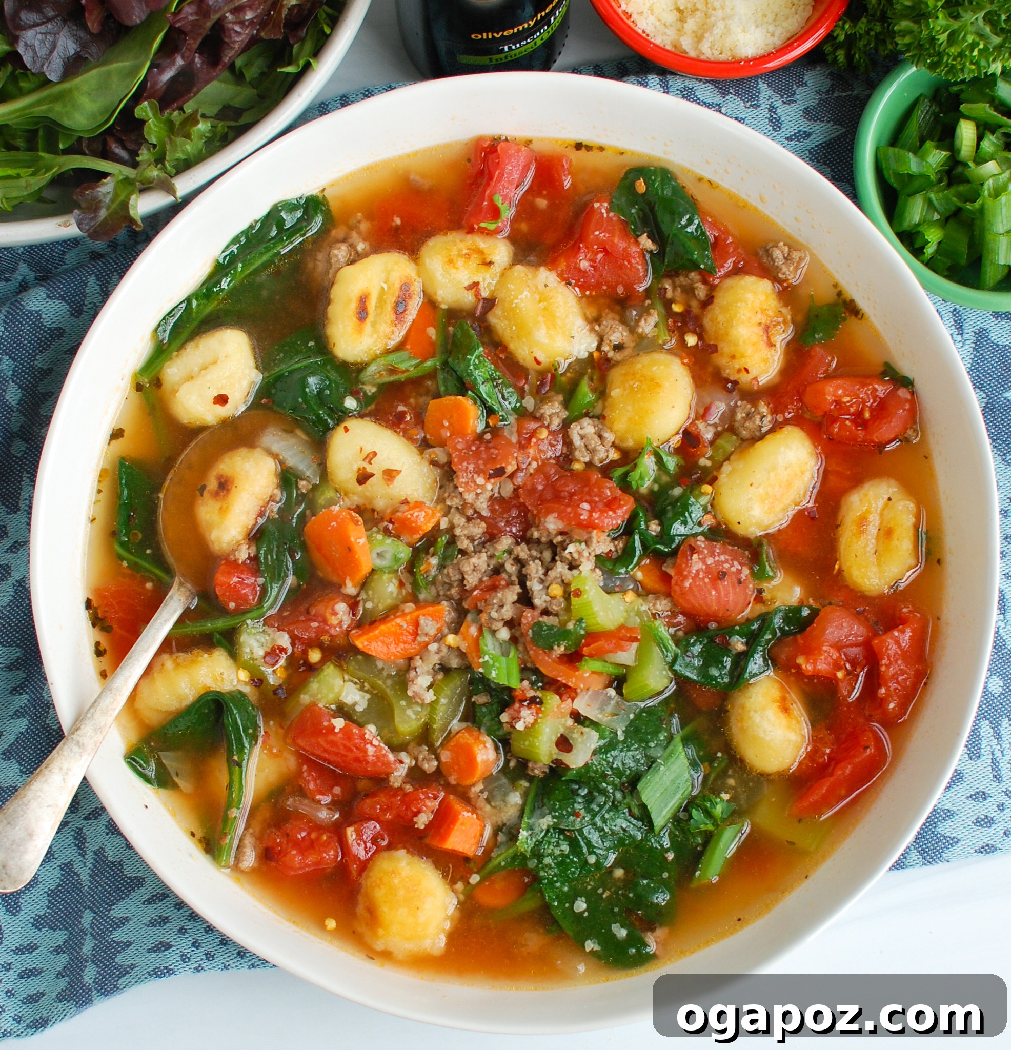 A serving of Easy Sausage Gnocchi Soup in a white bowl, garnished with fresh herbs.
