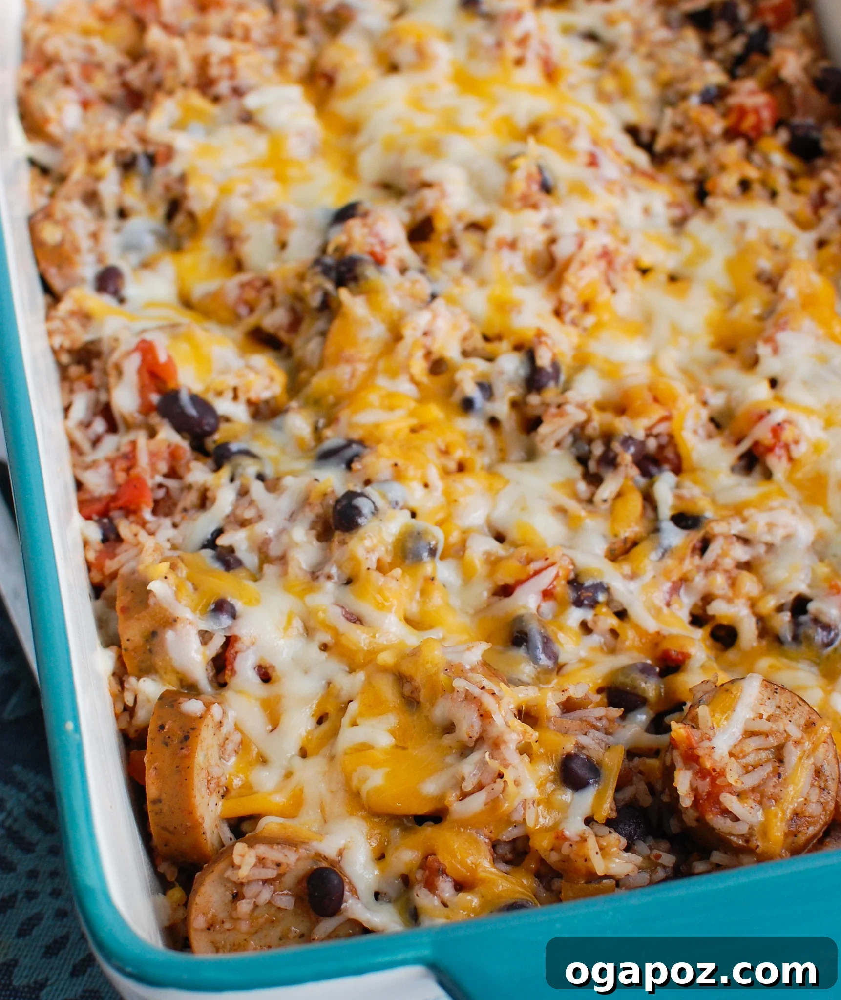 The finished Sausage and Bean Casserole in a teal baking dish, fresh from the oven.