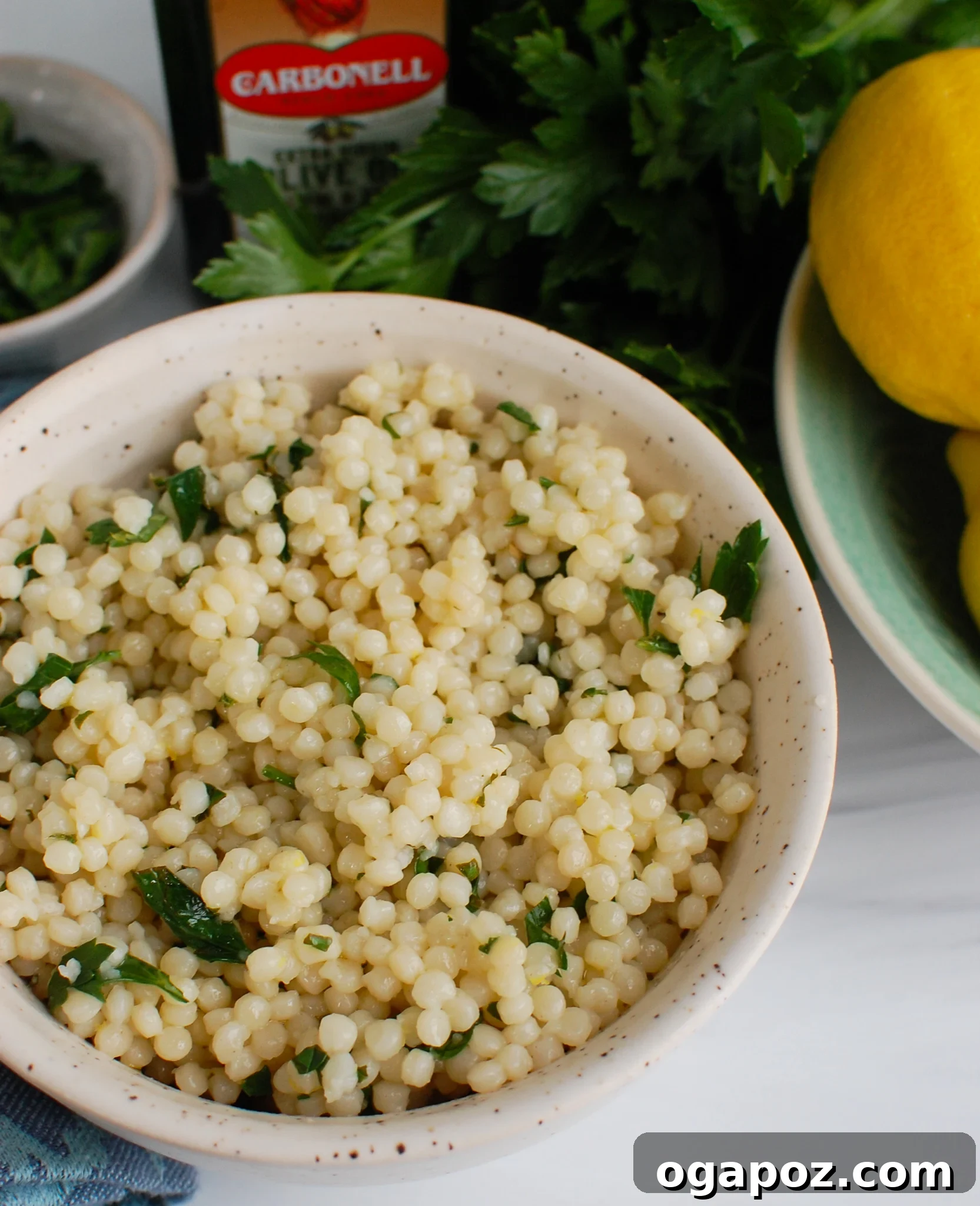 Sunshine Lemon Pearl Couscous 3 Close-up of Lemon Pearl Couscous garnished with a generous amount of fresh parsley and basil, showing its vibrant color and texture.
