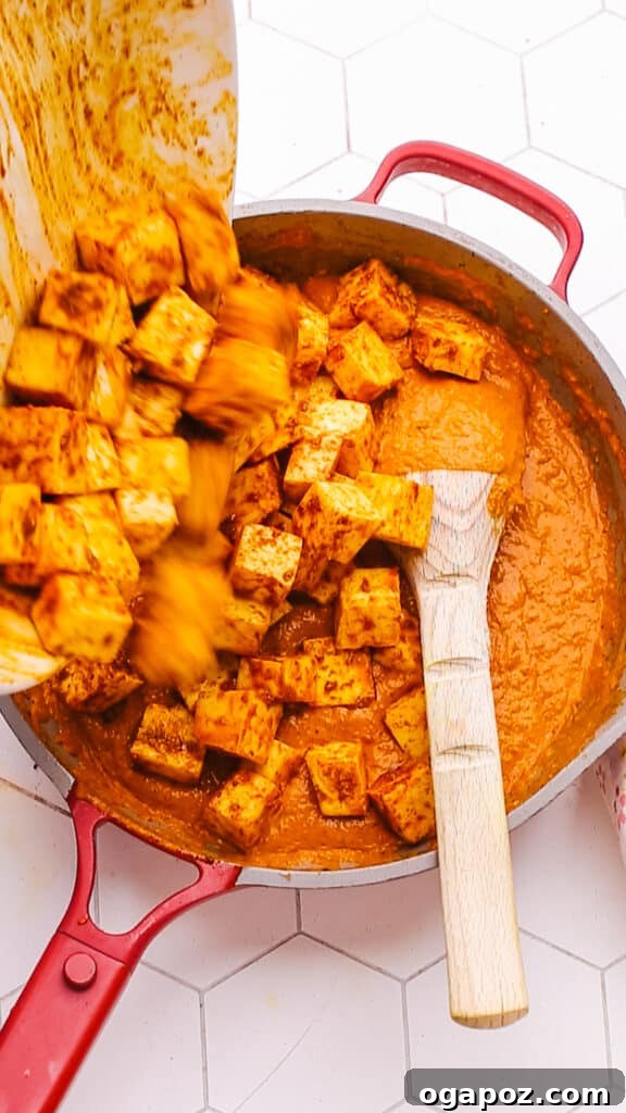 Creamy Butter Paneer 14 Adding perfectly marinated paneer cubes to the simmering, rich Butter Paneer sauce in a pan.
