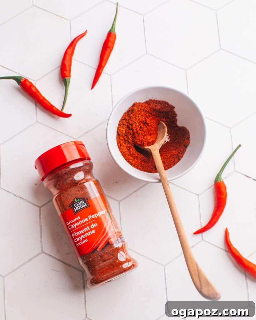 Creamy Butter Paneer 5 Close-up photograph showcasing fresh cayenne peppers, a bowl of ground cayenne pepper, and a jar of chili powder.