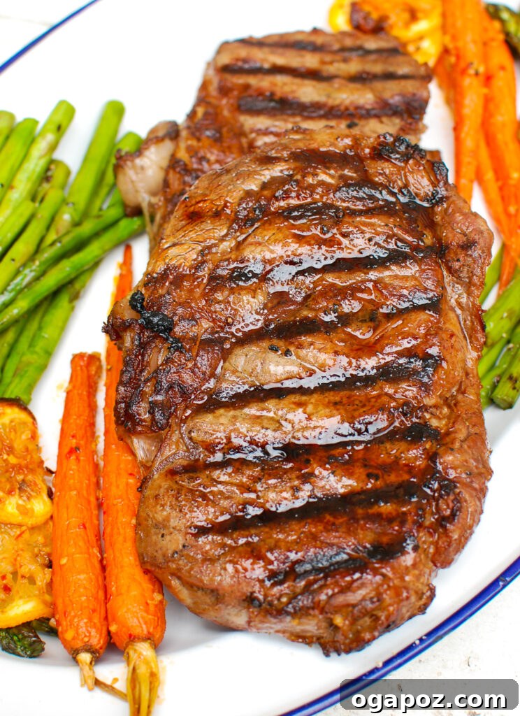 Grilled Ribeye with Lemon Garlic Butter 3 Lemon Garlic Butter Grilled Ribeye steak resting on a cutting board