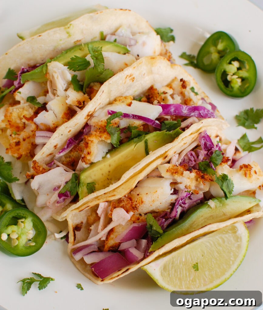 Effortless Cod Fish Tacos 2 Easy Cod Fish Tacos on a white plate, garnished with cilantro and red onion