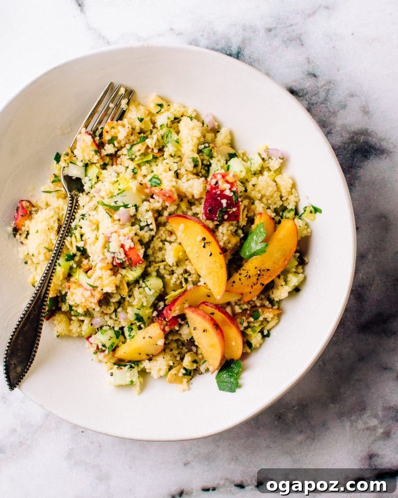 35+ Irresistible Side Dishes for Salmon 18 Couscous salad with a fork, showing fluffy grains and fresh herbs.