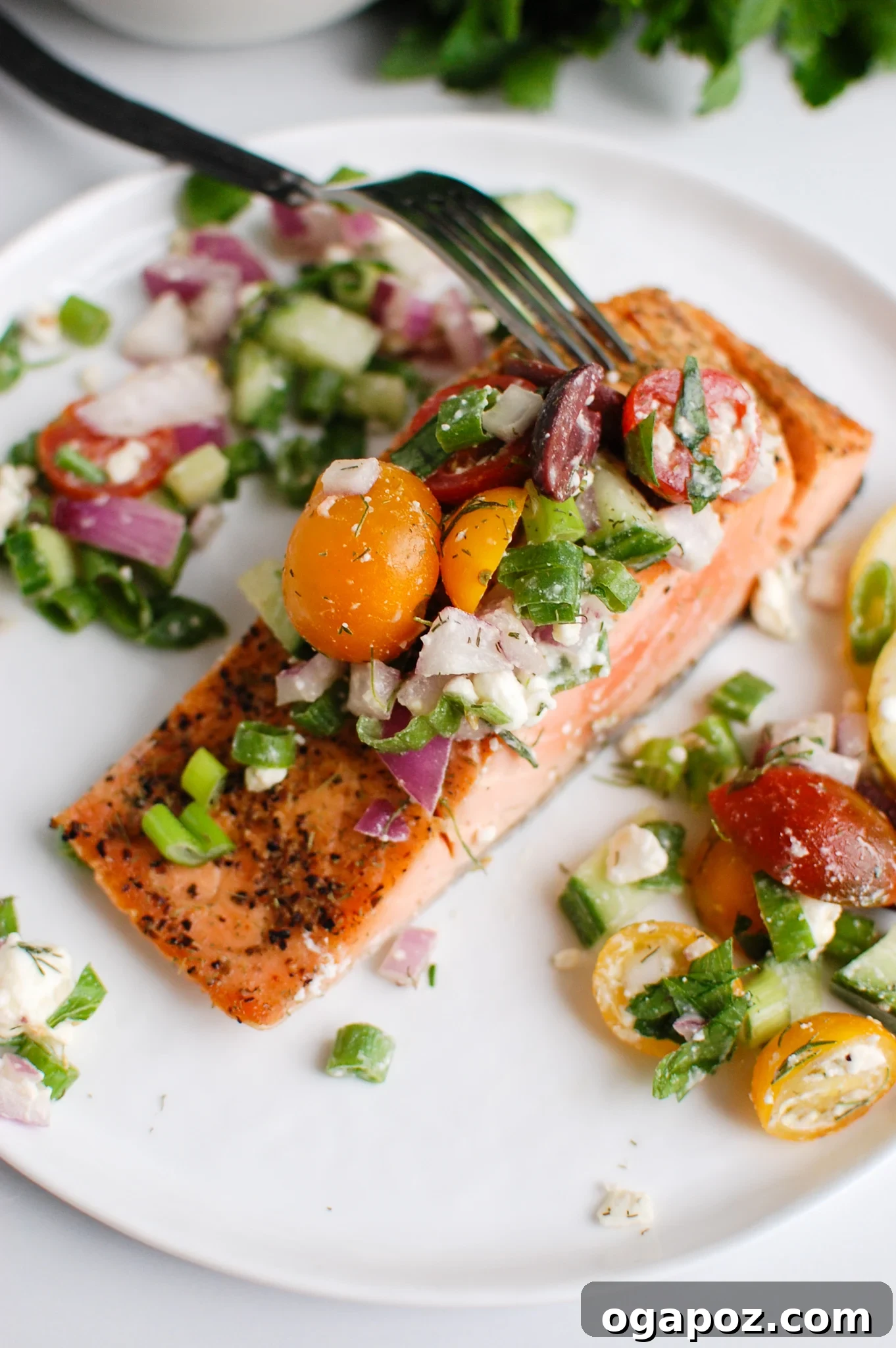 Sun-Kissed Mediterranean Baked Salmon 5 a fork cutting into a filet of salmon.