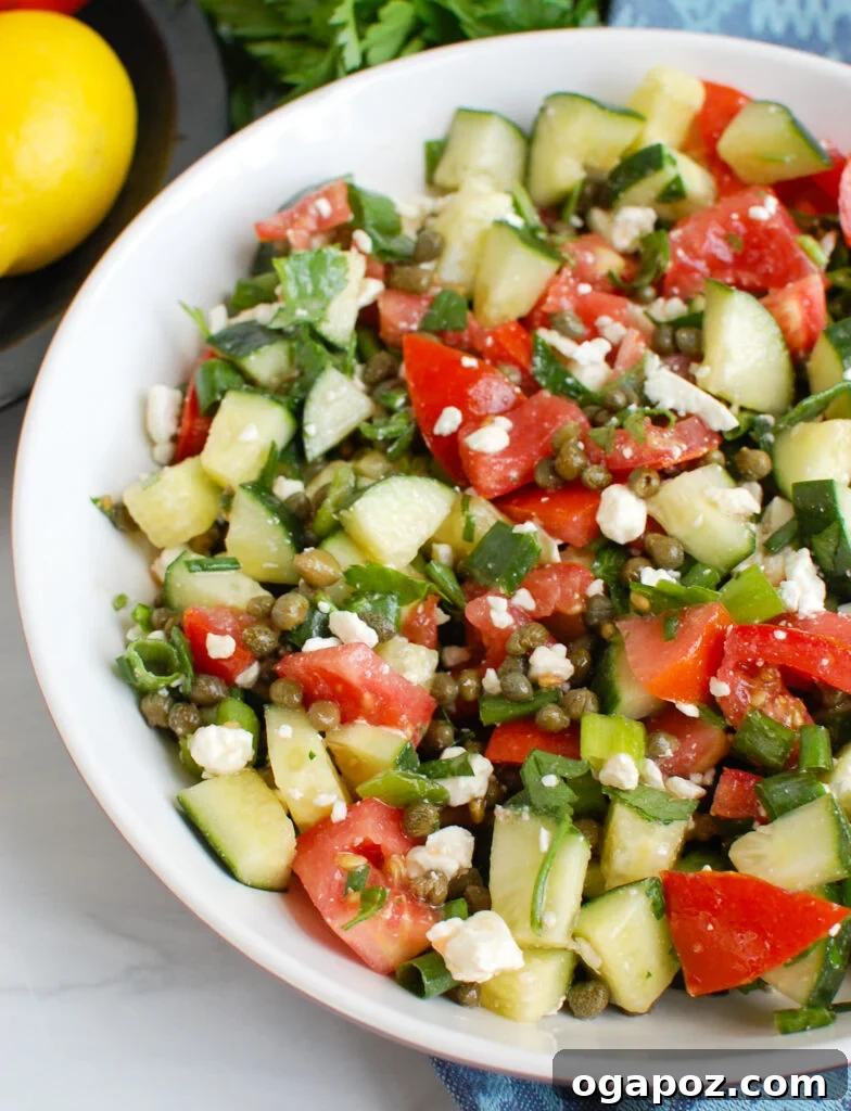 Vibrant Tomato and Cucumber Salad with Capers in a white bowl, ready to serve.