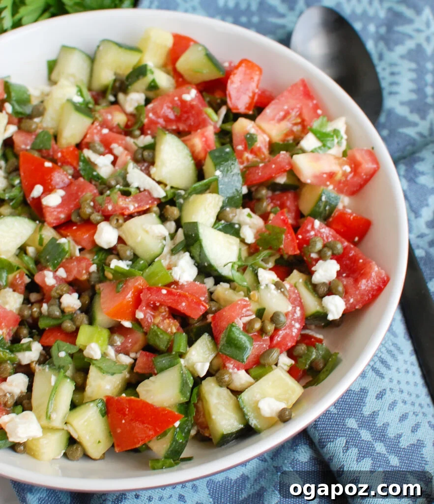 Tomato and Cucumber Salad with Capers and crumbled feta cheese, beautifully arranged.