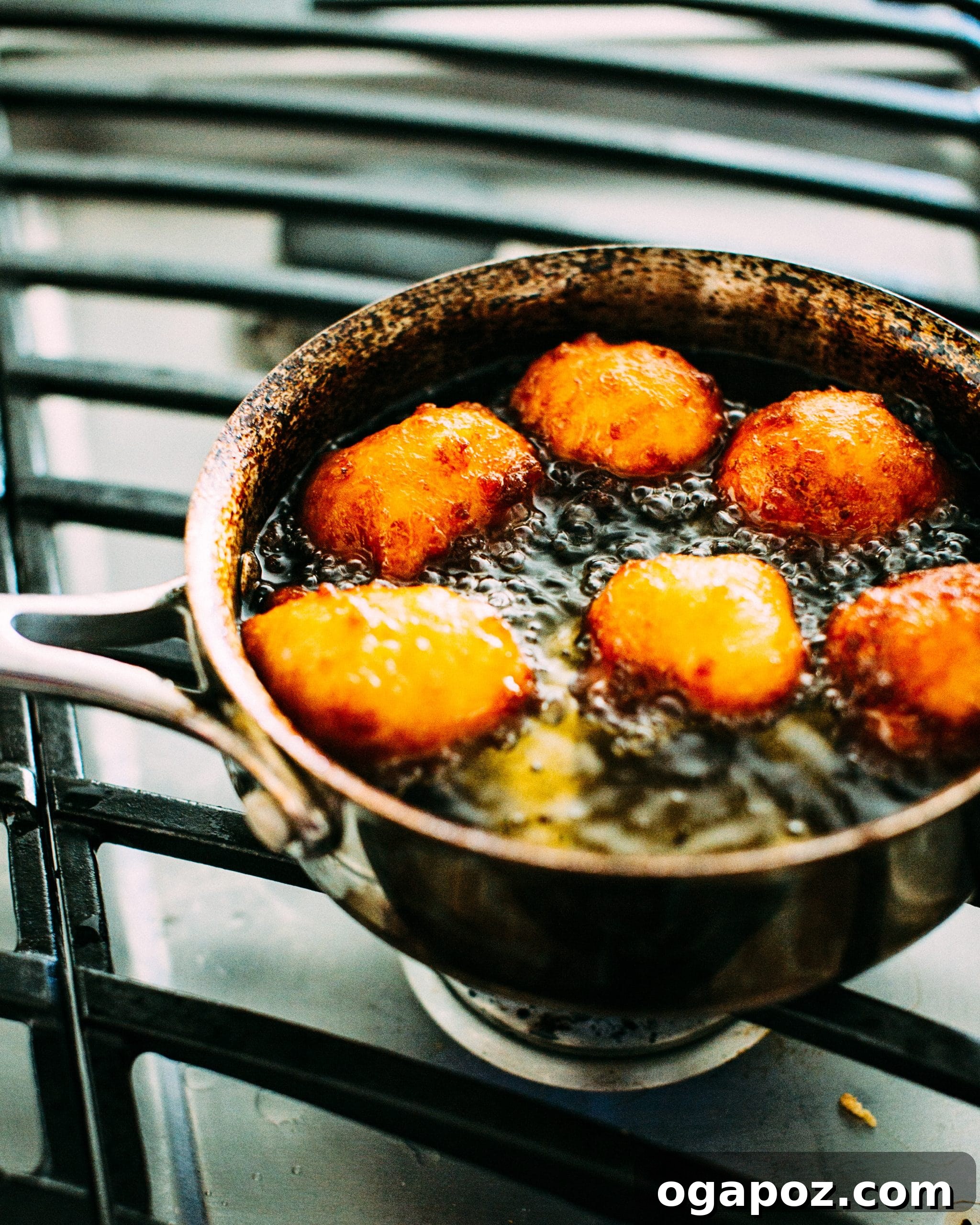 Melt-in-Your-Mouth Gulab Jamun: Surprisingly Easy Recipe 4 gulab jamun being fried on a stovetop