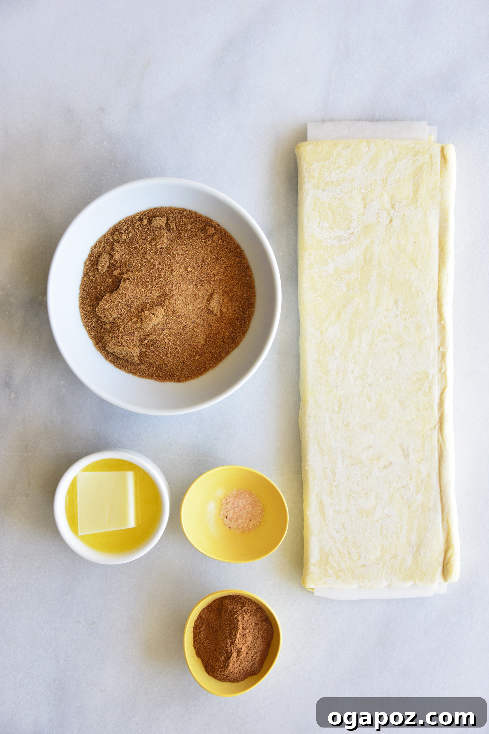 Effortless Cinnamon Puff Pastry Swirls 3 All the essential simple ingredients for the Easy Puff Pastry Cinnamon Swirls Recipe laid out on a rustic surface.