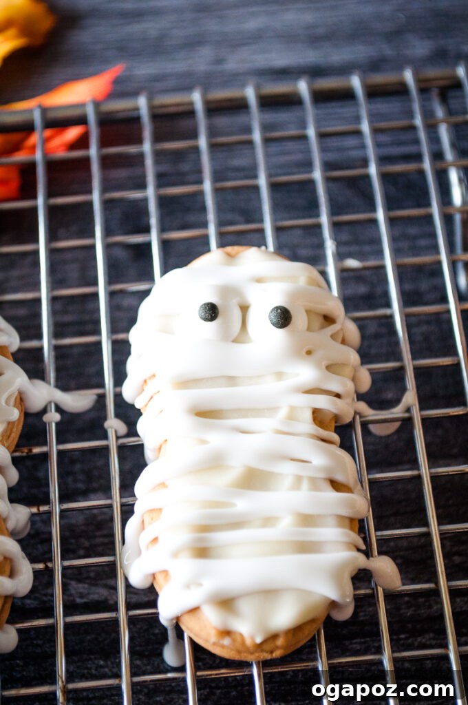 Spooky Mummy Cookies 2 Mummy Cookies on a cookie sheet, perfectly decorated for Halloween