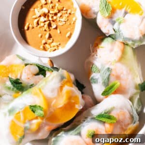 Spring rolls on a plate with peanut sauce.