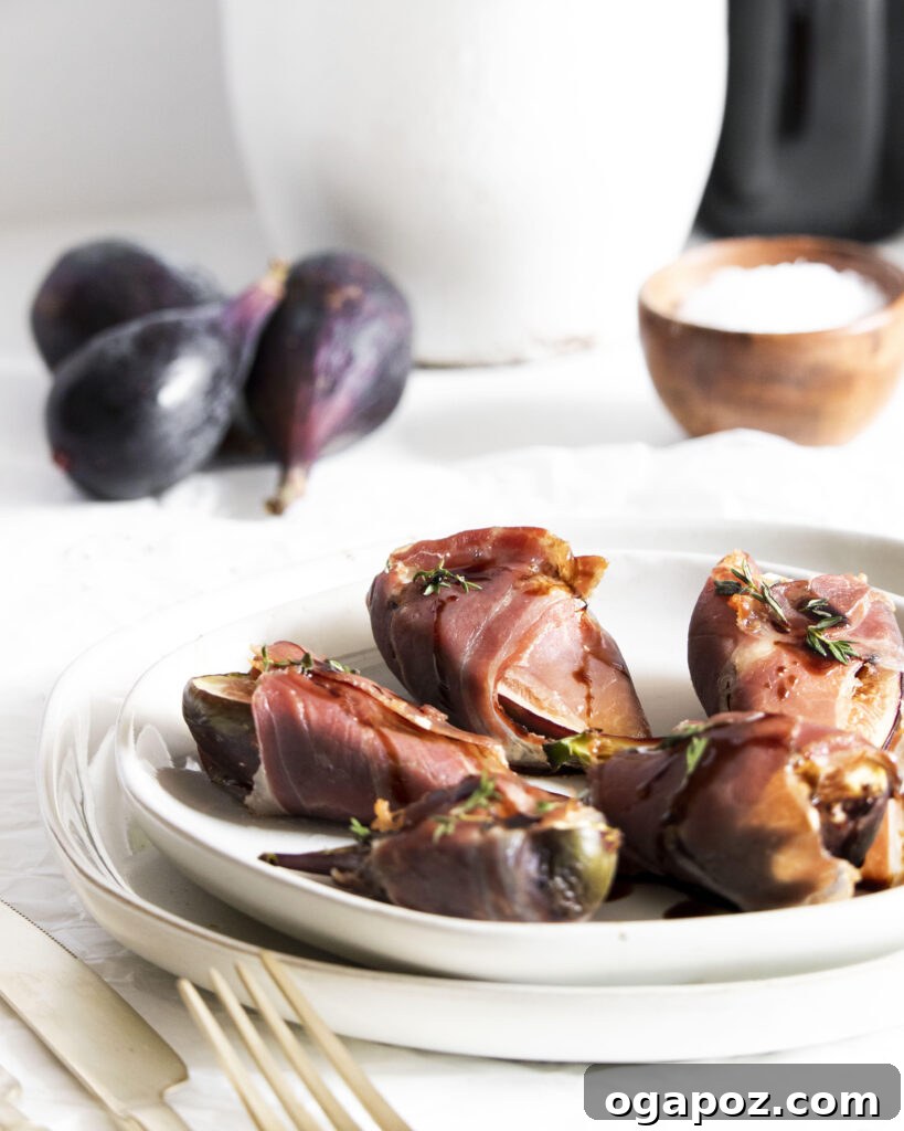 Fig & Goat Cheese Jewels Wrapped in Prosciutto 2 Goat Cheese Figs Wrapped in Prosciutto on a serving plate, drizzled with balsamic and honey