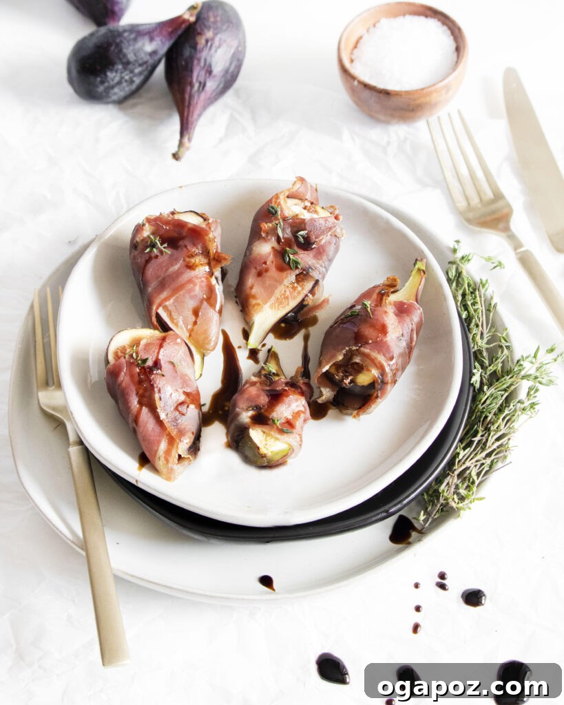 Fig & Goat Cheese Jewels Wrapped in Prosciutto 4 Goat Cheese Figs Wrapped in Prosciutto with balsamic glaze drizzled over them on a white platter
