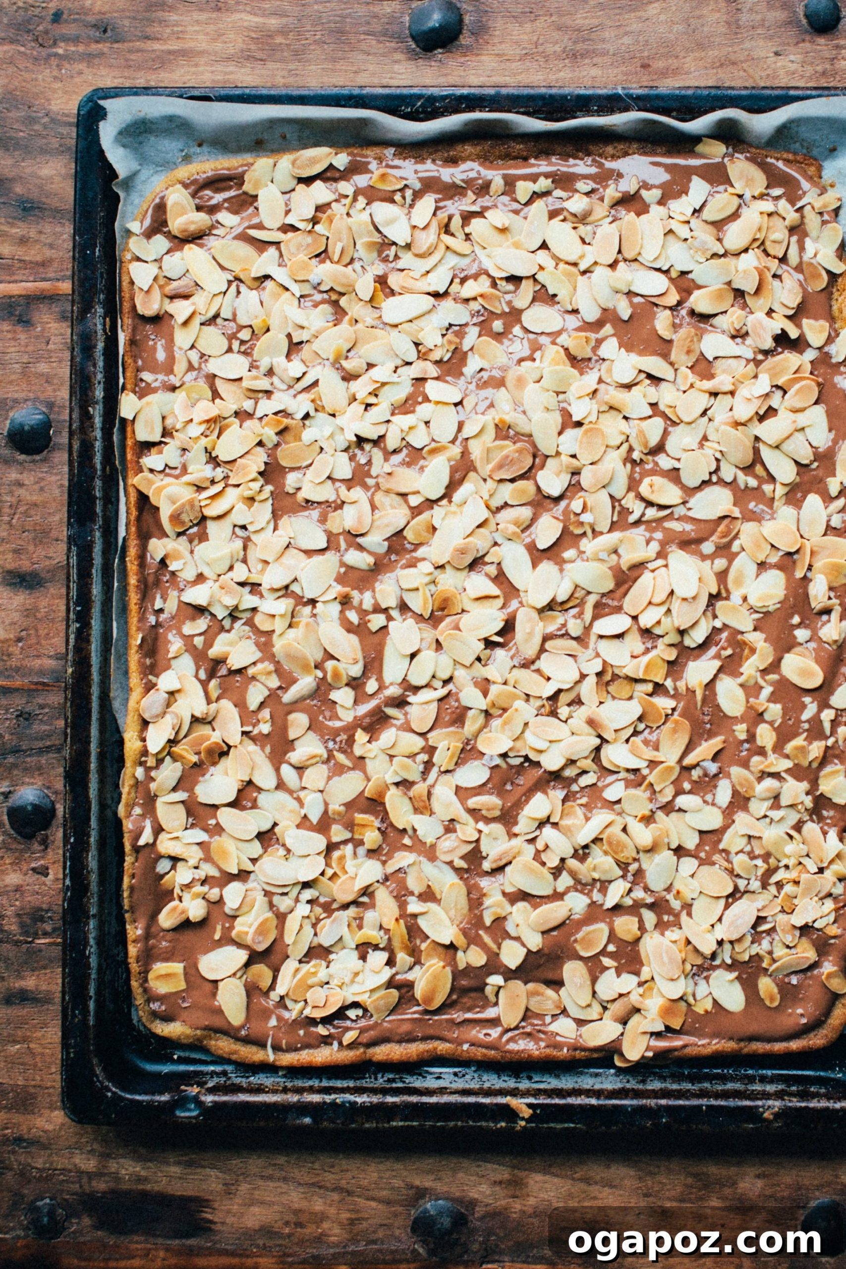 Sweet & Salty Toffee Cookie Crunch 4 Salted toffee cookie bark cooling in a pan with melted chocolate and almonds