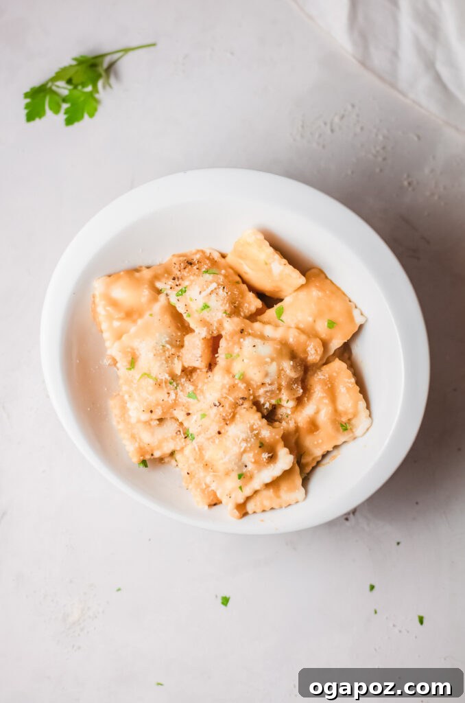 Brown Butter Sage Pumpkin Ravioli 8 A bowl of Creamy Pumpkin Ravioli topped generously with grated Parmesan cheese and fresh sage.