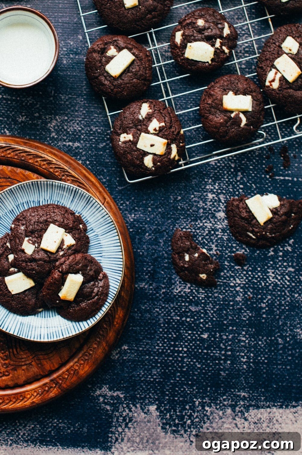 A close-up view of a freshly baked chewy dark chocolate cookie, showcasing its cracked top and visible white chocolate chunks.