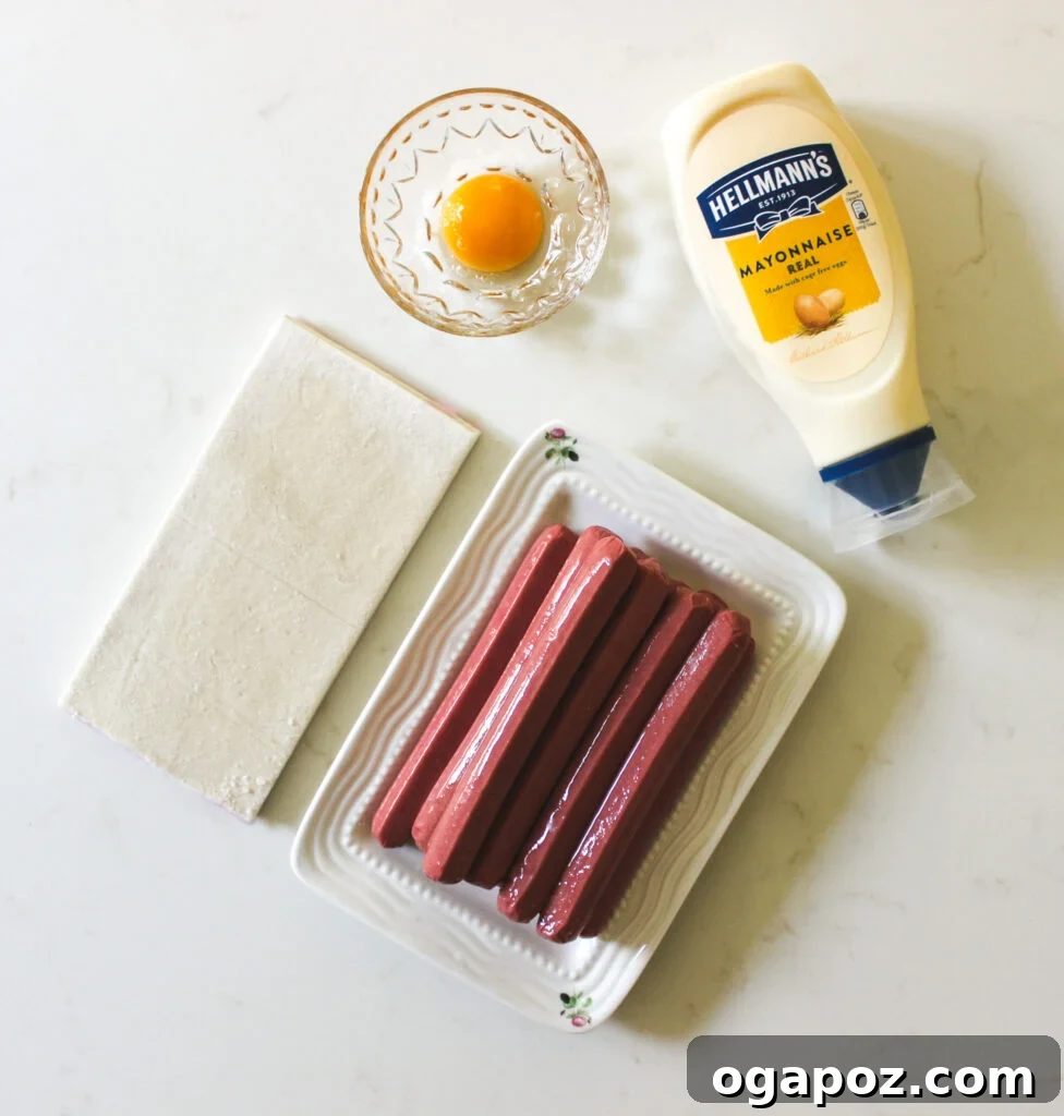 Spooky Sausage Wraps 4 The simple ingredients for Mummy Hot Dogs: hot dogs, puff pastry, and an egg in a bowl.