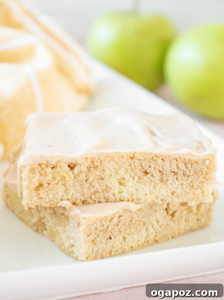 Autumn Apple Bars with Pumpkin Spice Glaze 2 A plate of perfectly sliced Apple Bars with thick, creamy Pumpkin Pie Spice Icing, ready to be enjoyed as a fall treat.