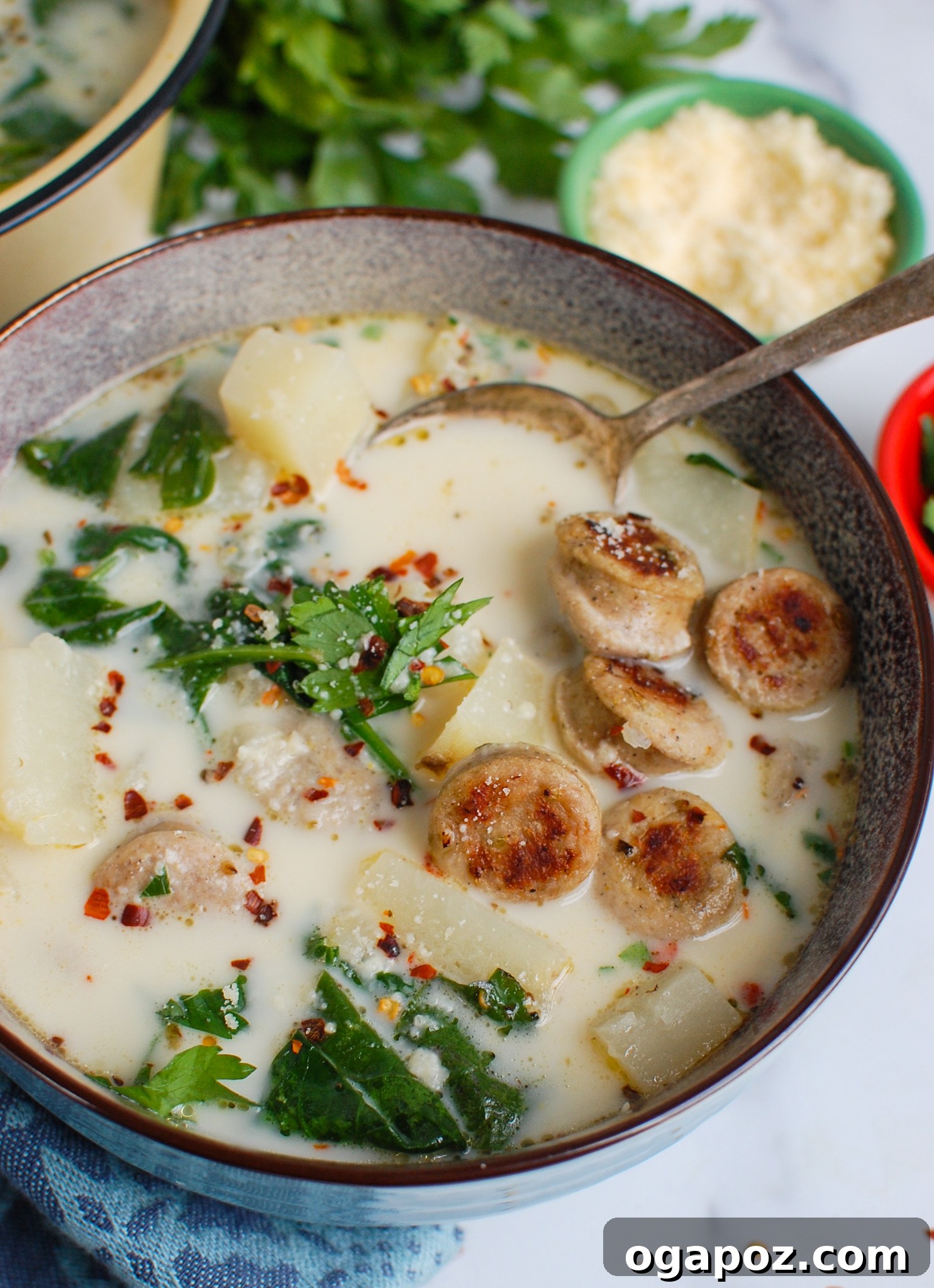 Effortless Slow Cooker Zuppa Toscana 2 Slow Cooker Zuppa Toscana with spoon, garnished with fresh herbs.