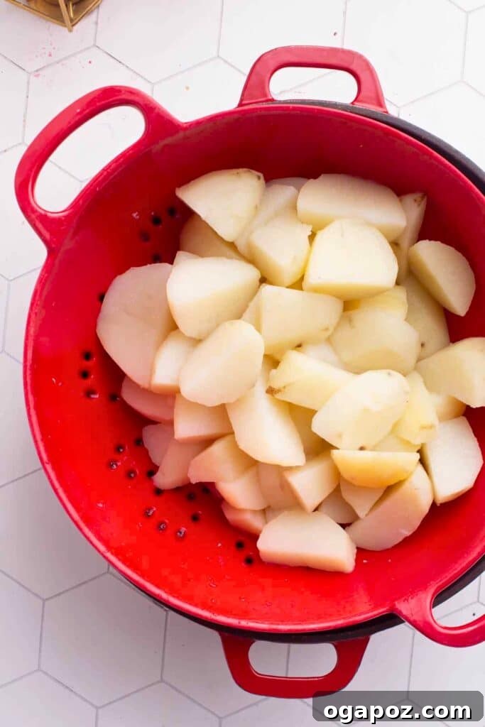 Effortless Creamy Paneer Kofta Curry 13 Boiled potatoes in a colander, ready for mashing.