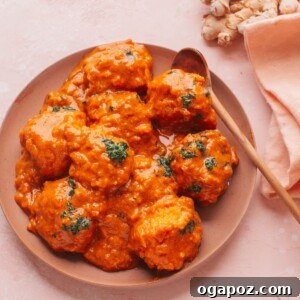 Malai Kofta on a plate with a spoon, garnished with fresh cilantro.