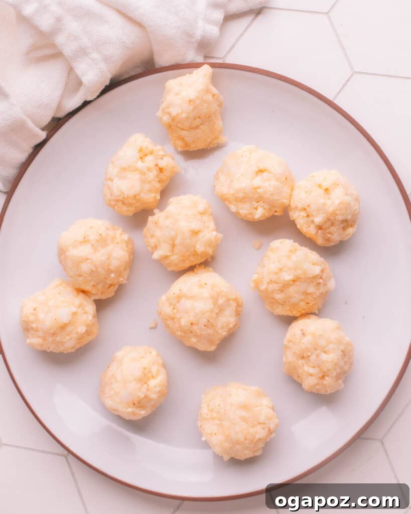 Effortless Creamy Paneer Kofta Curry 10 Shaped Paneer Koftas ready for frying on a plate.