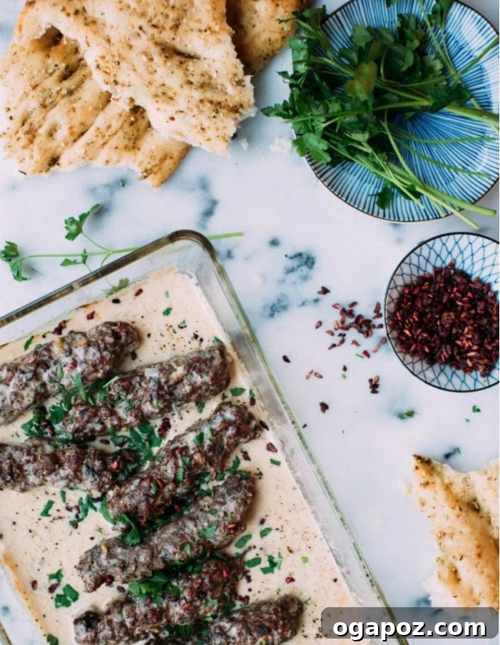 Creamy Tahini Lamb Kofta 2 Succulent Lamb Kofta in Tahini Sauce, garnished with fresh parsley and pomegranate arils